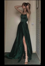 Woman in emerald green evening gown with high slit from ZAPDRESS standing indoors