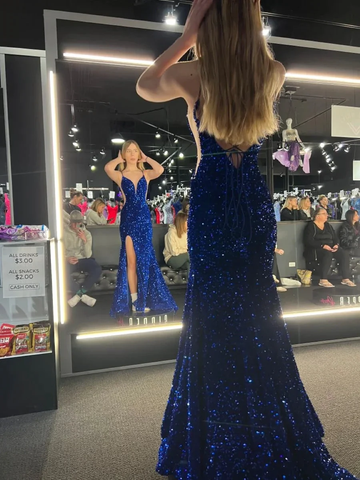 Woman in sparkling blue evening gown with side slit, trying on dress at ZAPDRESS store