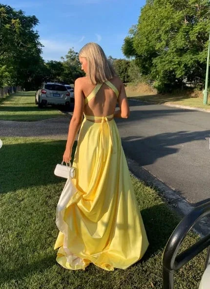 Woman in yellow backless dress holding white purse outdoors, ZAPDRESS formal fashion scene