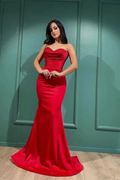 Woman wearing elegant red strapless evening gown from ZAPDRESS, standing indoors.