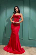 Woman wearing elegant red strapless evening gown from ZAPDRESS, standing indoors.