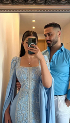 Couple posing in mirror, woman in ornate blue embroidered dress, man in light blue shirt, ZAPDRESS