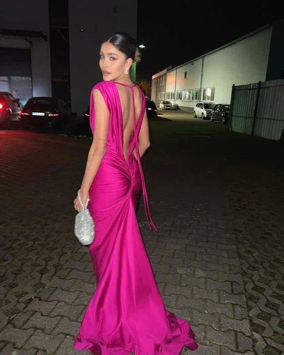 Woman in a vibrant magenta evening gown holding a silver clutch, night city backdrop, ZAPDRESS