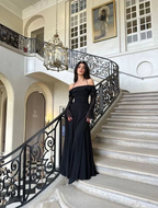 Woman in elegant black evening gown on grand staircase, ZAPDRESS fashion main hall