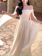 Elegant woman wearing off-shoulder cream dress outdoors, ZAPDRESS fashion style