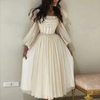Woman in elegant ivory midi dress with sheer long sleeves from ZAPDRESS