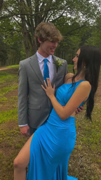 Couple in blue formal dress and gray suit smiling outdoors, prom fashion by ZAPDRESS