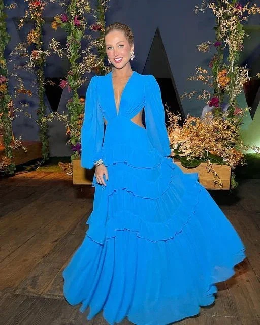 Woman in a flowing blue evening gown at floral event, ZAPDRESS fashion style