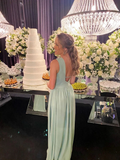 Woman in light blue formal dress at elegant event with large cake, flowers, and chandeliers