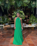 Woman in flowing green dress standing in lush botanical setting, ZAPDRESS fashion style