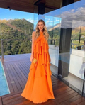 Woman in an orange ruffled dress on a modern deck with mountain view, ZAPDRESS fashion