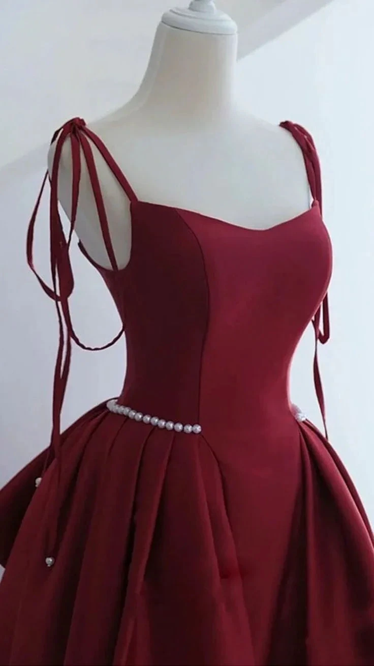 Elegant burgundy evening dress with pearl waist detail and tie straps on mannequin, ZAPDRESS
