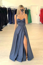 Woman in a navy blue evening gown with high slit at ZAPDRESS boutique, taking mirror selfie