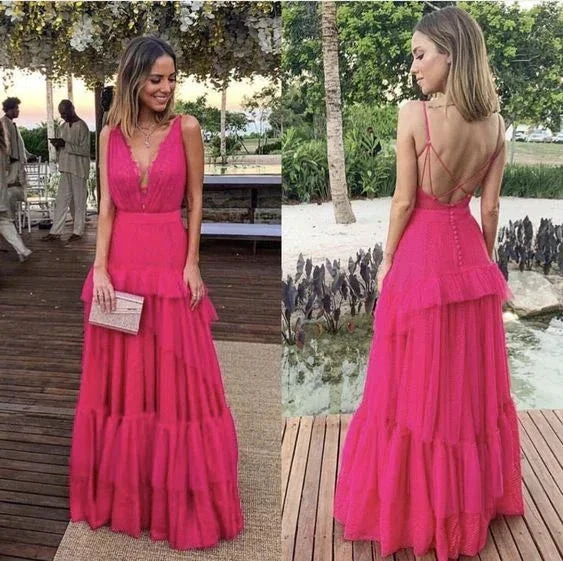 Woman wearing a vibrant pink tiered maxi dress with deep V-neck and strappy back outdoors