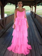 Woman in a bright pink tiered tulle dress posing on a wooden bridge, ZAPDRESS fashion