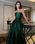 Woman in elegant emerald green strapless gown with jewelry, posing indoors at ZAPDRESS