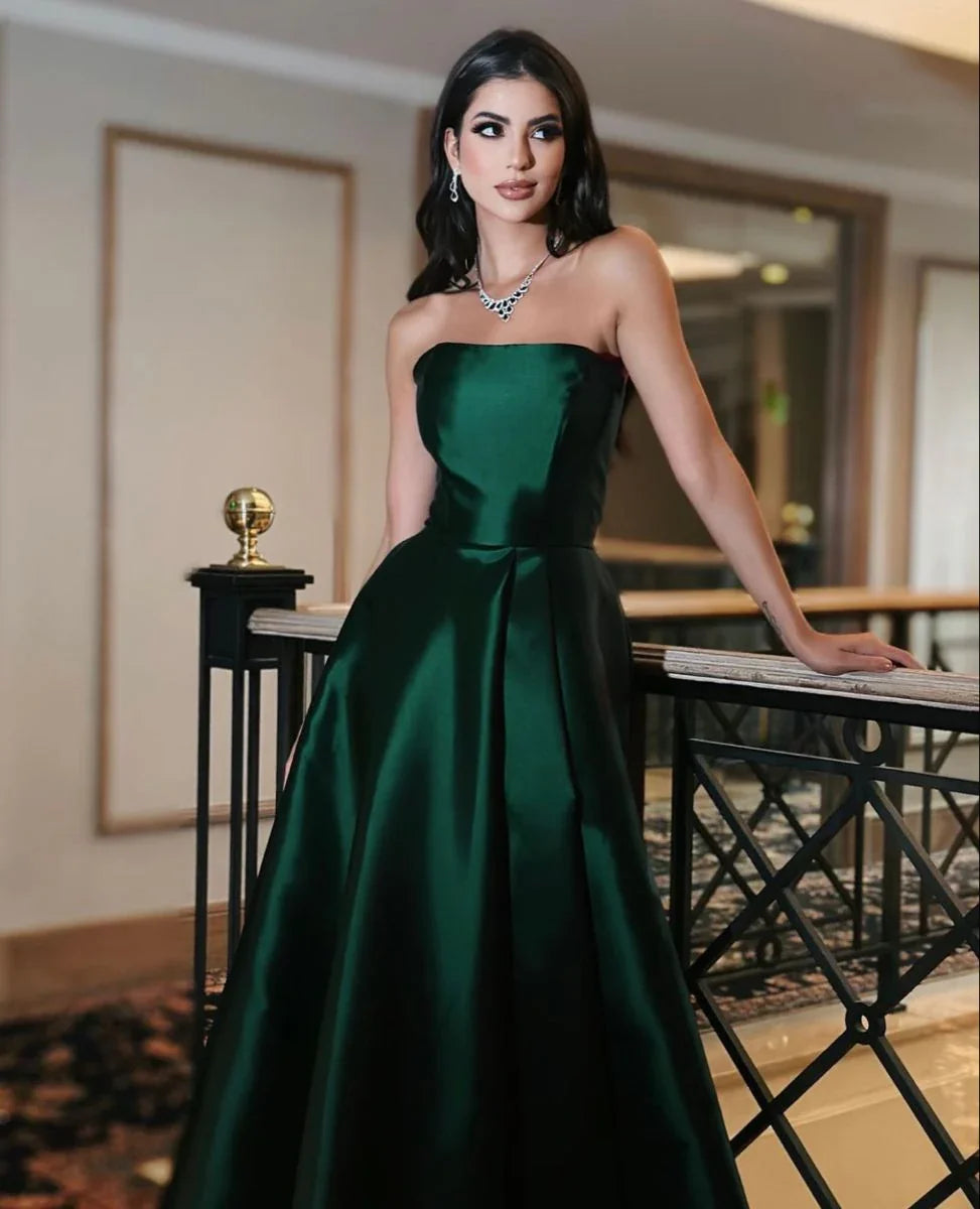 Woman in elegant emerald green strapless gown with jewelry, posing indoors at ZAPDRESS