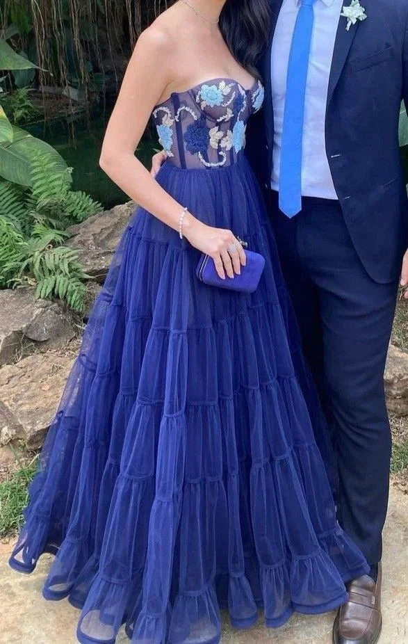 Woman in strapless navy tulle evening gown with floral bodice, holding clutch, ZAPDRESS