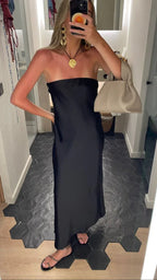 Woman in strapless black satin dress, gold accessories, holding beige bag, ZAPDRESS style