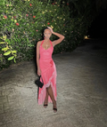 Woman in a pink ruffled dress poses outdoors at night with floral backdrop, ZAPDRESS fashion