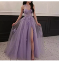 Woman wearing a purple tulle evening gown with floral details and high slit from ZAPDRESS