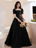 Elegant woman in long black evening dress with puff sleeves holding a bouquet, ZAPDRESS