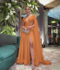 Woman in elegant orange evening gown with high slit, holding clutch, ZAPDRESS fashion