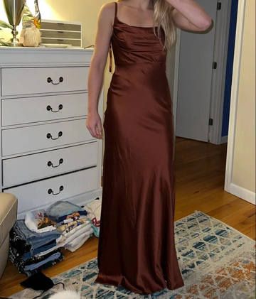 Woman wearing a brown satin gown from ZAPDRESS, standing in a bedroom with hardwood floor.