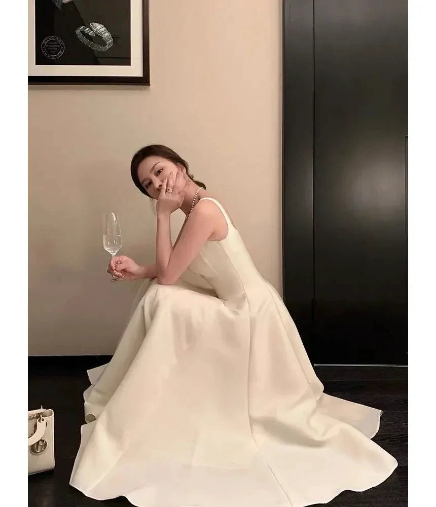 Elegant woman in a white evening gown holding a wine glass, ZAPDRESS fashion style
