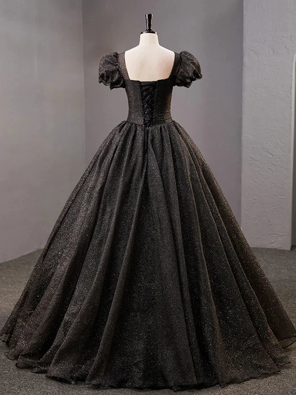 Elegant black ball gown with puff sleeves and lace-up back on mannequin at ZAPDRESS