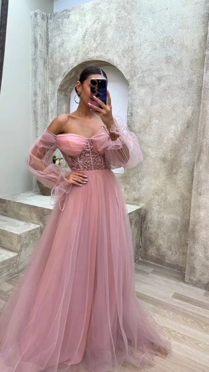 Woman in pink tulle off-shoulder gown with lace bodice posing indoors for ZAPDRESS
