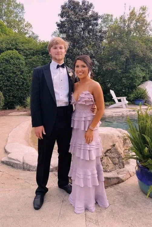 Young couple in formal attire, woman in ruffled lilac ZAPDRESS gown, standing by garden pool