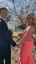 Young couple in formalwear, woman in coral pink prom dress, holding bouquet, outdoors, ZAPDRESS