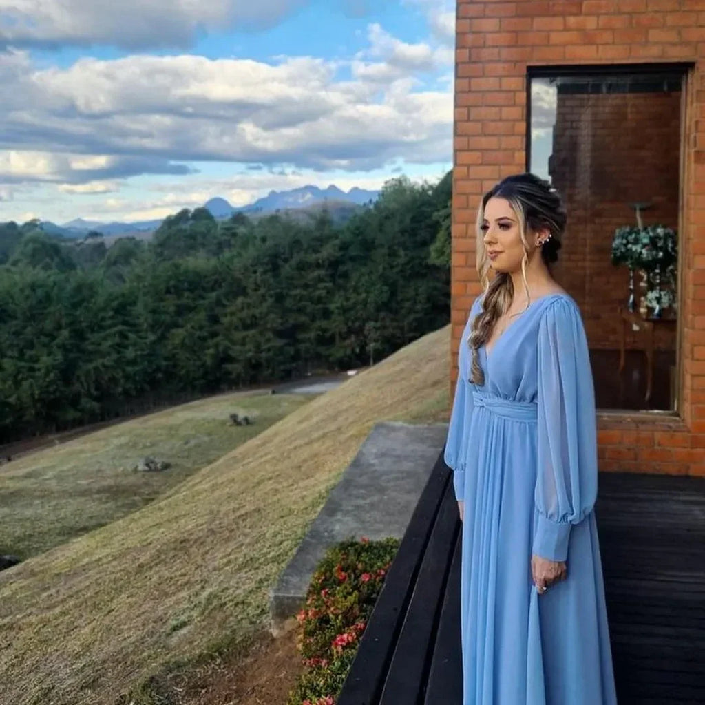 Woman in a long blue dress standing on a terrace with forest and mountains, ZAPDRESS