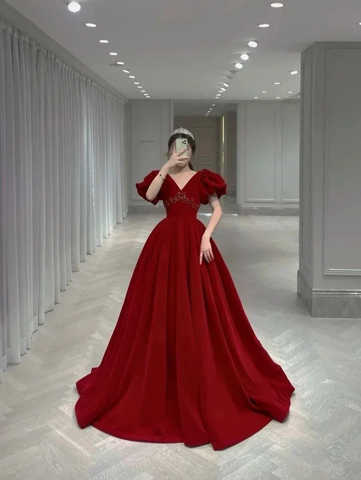 Woman in a red ball gown with puff sleeves taking a mirror selfie in a modern showroom, ZAPDRESS fashion