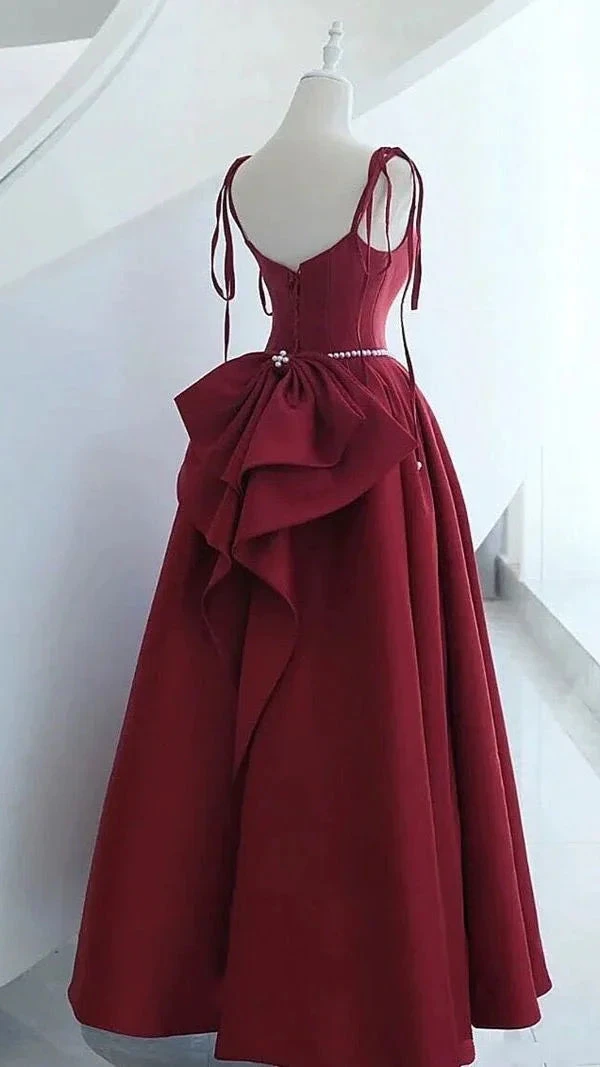 Elegant burgundy evening dress with bow detail on mannequin at ZAPDRESS