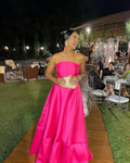 Woman in bright pink strapless evening gown holding clutch at elegant outdoor event, ZAPDRESS style
