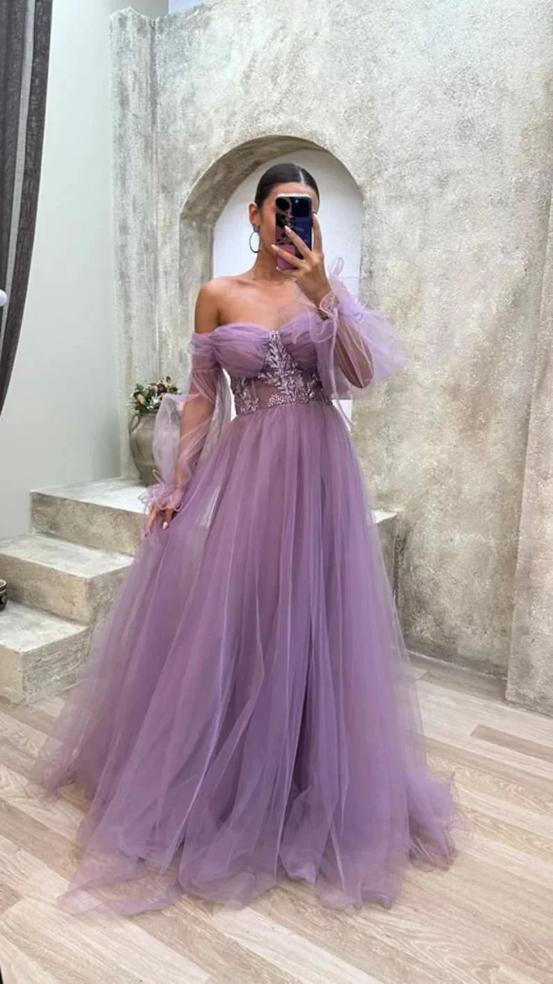 Woman in a lavender tulle off-shoulder evening gown standing indoors at ZAPDRESS