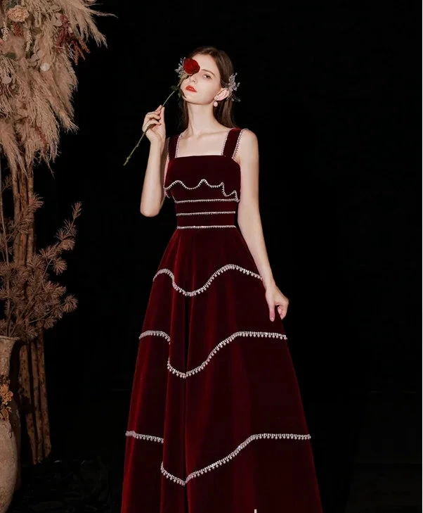Woman in elegant burgundy evening gown with silver trim, posing with rose, ZAPDRESS fashion