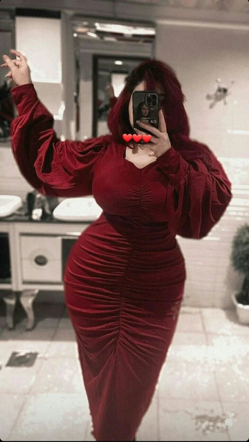 Woman in a fitted red velvet dress taking a mirror selfie, ZAPDRESS fashion style.