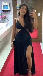 Woman in black cutout evening dress with thigh-high slit, taking mirror selfie on red carpet at ZAPDRESS.