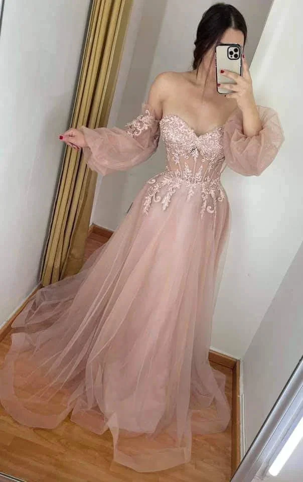 Woman in mirror selfie wearing blush pink off-shoulder tulle evening dress with lace details