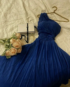 Elegant blue one-shoulder dress on bed with roses, Chanel perfume, and gift box, ZAPDRESS style