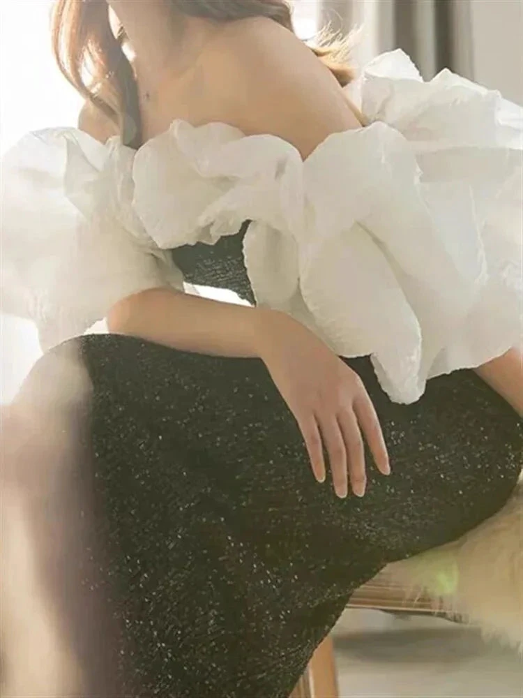 Woman in off-shoulder black dress with large white ruffled sleeves, ZAPDRESS fashion