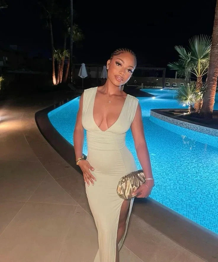 Woman in elegant light green evening dress posing by a lit pool at night, ZAPDRESS style