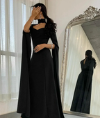 Woman in elegant black evening gown with dramatic sleeves posing by ornate mirror, ZAPDRESS
