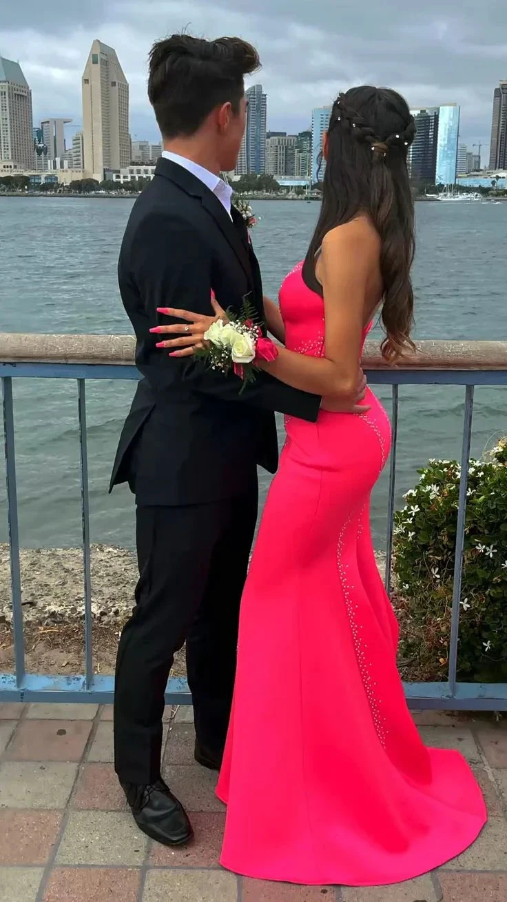 Couple in formalwear, woman in bright pink dress, by waterfront cityscape, ZAPDRESS style