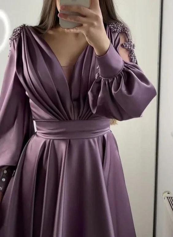 Woman wearing elegant mauve satin dress with beaded shoulders and pleated skirt from ZAPDRESS