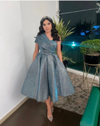 Woman in sparkly silver one-shoulder dress at indoor event, ZAPDRESS fashion