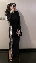 Woman in black ZAPDRESS gown with silver pearl accents, holding a clutch, taking mirror selfie
